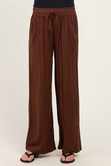 woman wearing brown maternity palazzo pants with an elastic waistband and drawstring detail