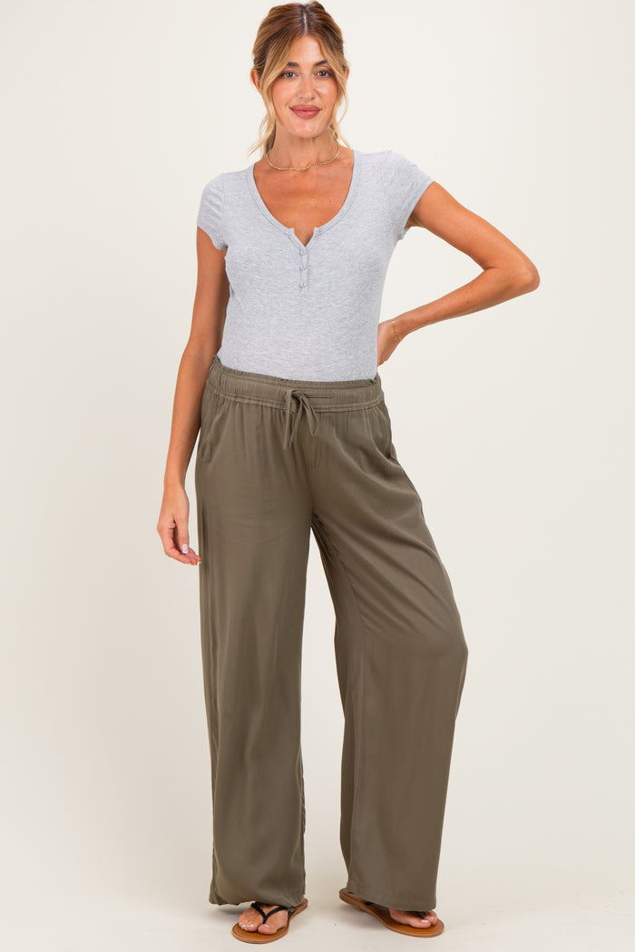 woman wearing a grey short sleeve maternity top and olive green wide-leg pants