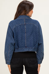 woman wearing a dark wash cropped denim jacket with a dotted pattern over a black top and jeans