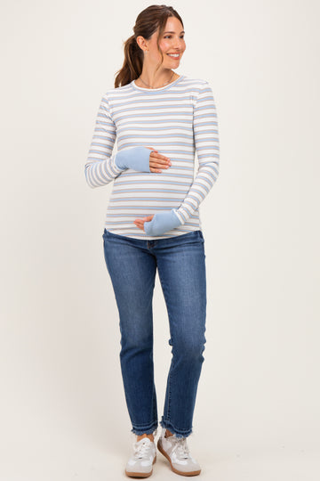 woman wearing a light blue and white striped maternity top with thumbholes and blue cuffs, holding her baby bump