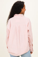 woman wearing a pink and white striped maternity shirt with a relaxed back design and button-up detail