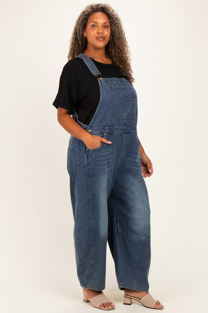 woman wearing a black short sleeve top and blue denim overalls with side pockets and a relaxed fit