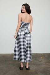 woman wearing a black and white checkered strapless maxi dress, showing the back view