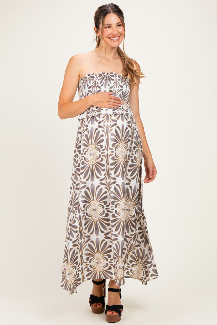 woman wearing a strapless floral maxi maternity dress and holding her baby bump