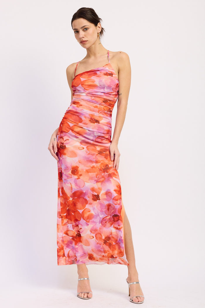 woman wearing a pink and orange floral maxi dress with a side slit and halter neckline