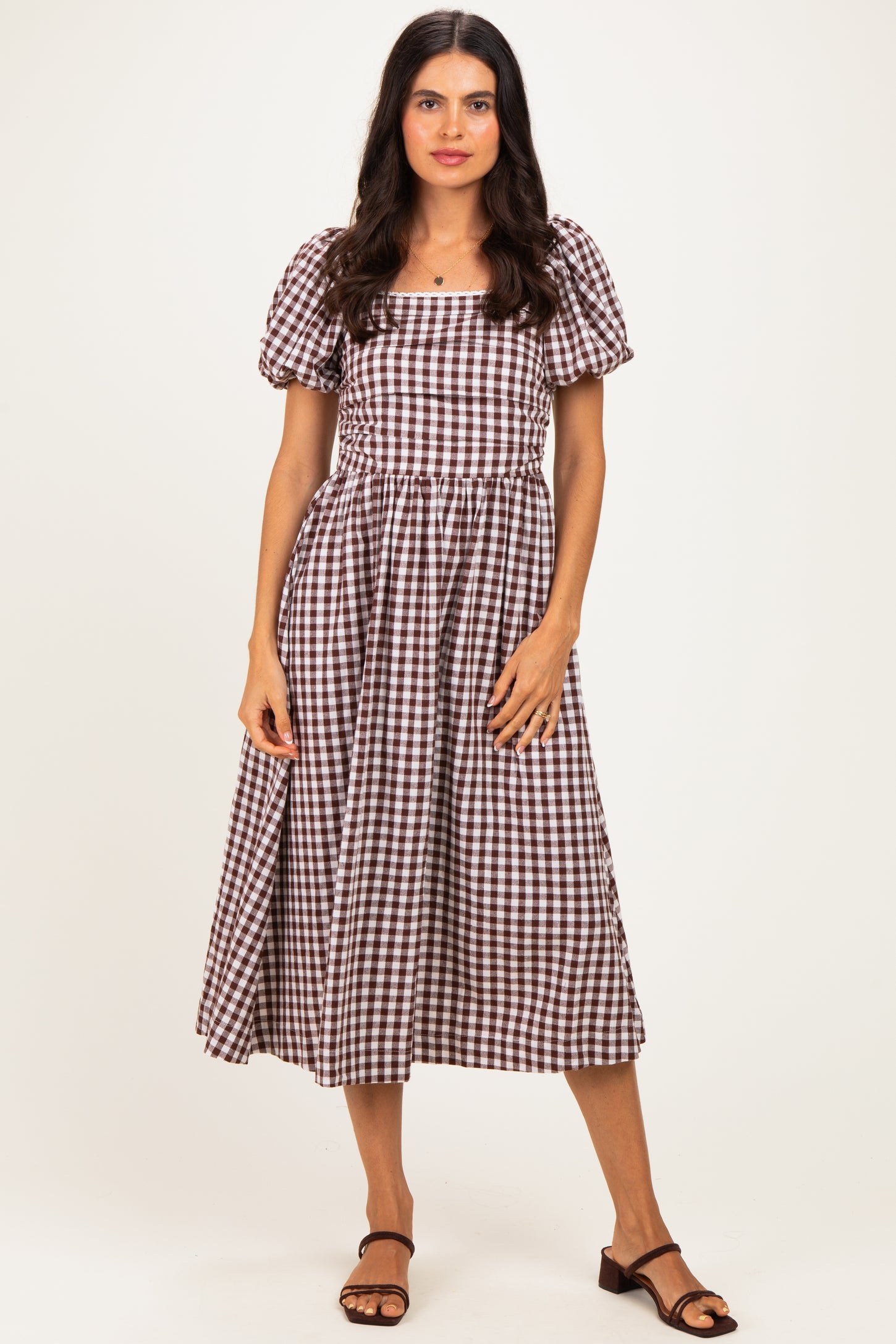 woman wearing a brown and white checkered midi dress with puff sleeves and a square neckline