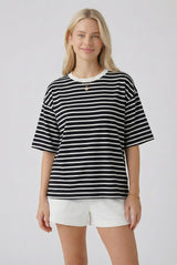 woman wearing a black and white striped oversized t-shirt paired with white shorts