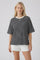 woman wearing a black and white striped oversized t-shirt paired with white shorts