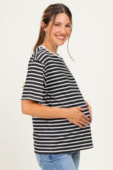 woman wearing a black and white striped maternity top and holding her baby bump