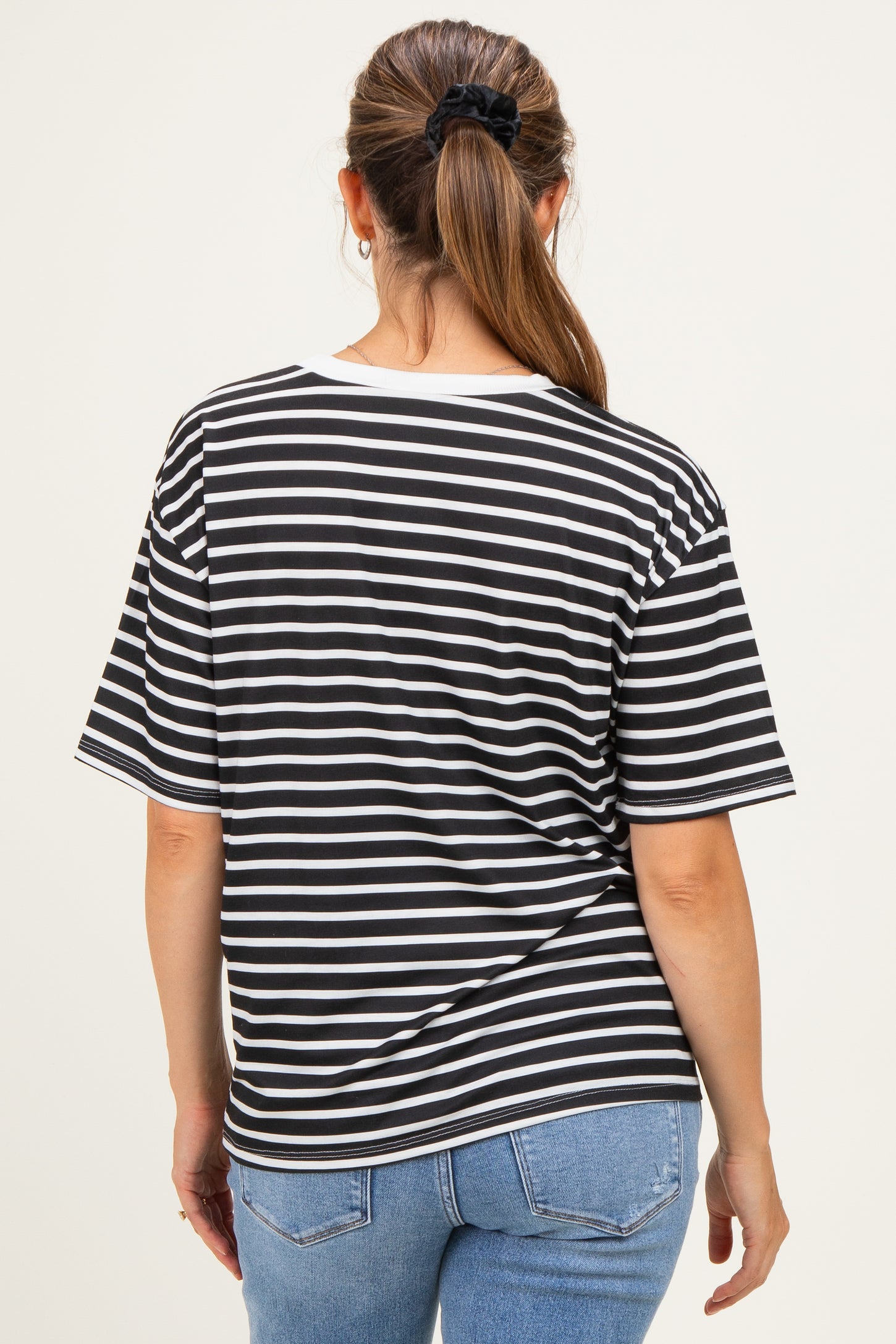 woman wearing a black and white striped maternity t-shirt with a relaxed fit and back view visible