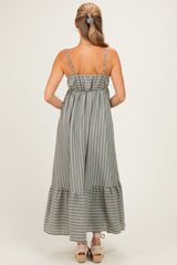 woman wearing a gray and white striped maxi dress with adjustable spaghetti straps and a ruffled hemline