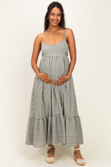 woman wearing a gray and white striped maternity dress with a tiered hem and holding her baby bump