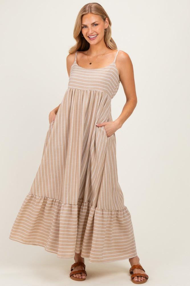 woman wearing a beige and white striped maxi dress with adjustable spaghetti straps and pockets