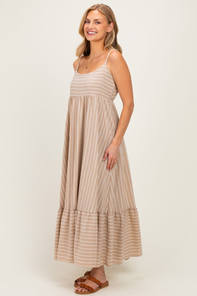 woman wearing a beige striped maxi dress with a tiered hem and adjustable spaghetti straps