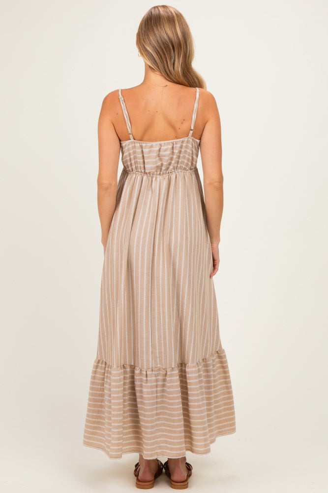 woman wearing a beige striped maxi dress with a ruffled hem and adjustable spaghetti straps