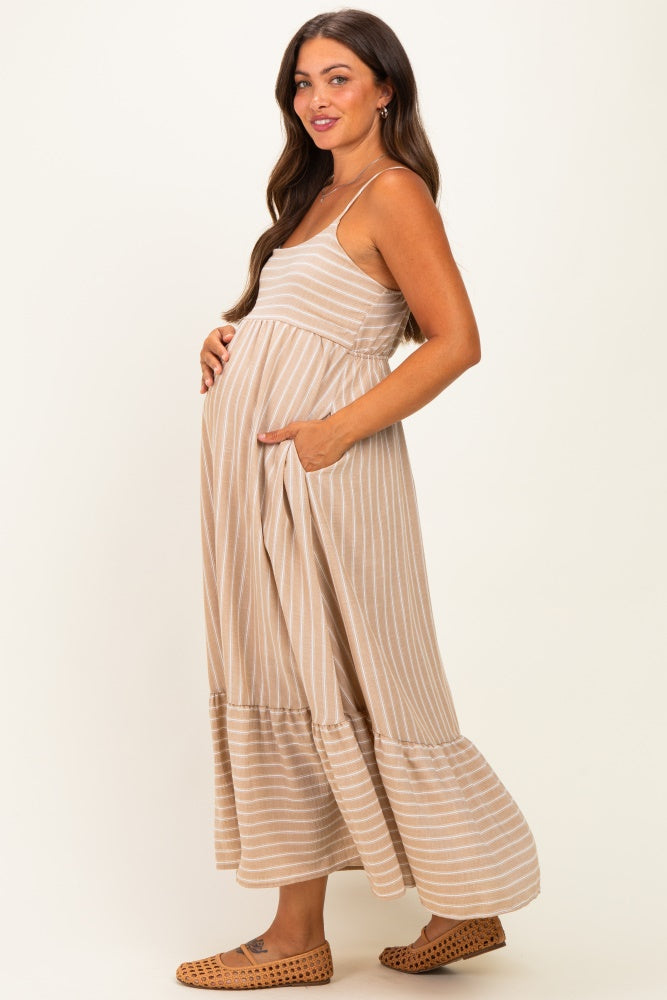 woman wearing a beige and white striped maternity maxi dress with pockets, showcasing her baby bump