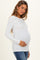 woman wearing a white long sleeve maternity top and holding her baby bump