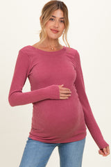 woman wearing a ribbed mauve maternity top and holding her baby bump
