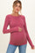 woman wearing a ribbed mauve maternity top and holding her baby bump
