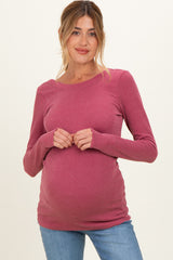 woman wearing a ribbed mauve maternity top and holding her baby bump