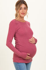 woman wearing a mauve ribbed maternity top and holding her baby bump