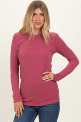 woman wearing a long sleeve ribbed burgundy top paired with blue jeans