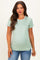 woman wearing a mint green short sleeve maternity top showcasing her baby bump