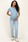 woman wearing a light blue short sleeve maternity top and jeans, gently holding her baby bump