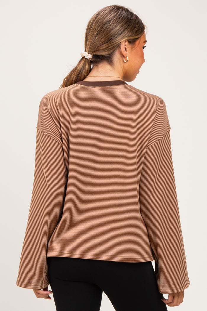 woman wearing a brown striped maternity top with wide sleeves, showing the back view