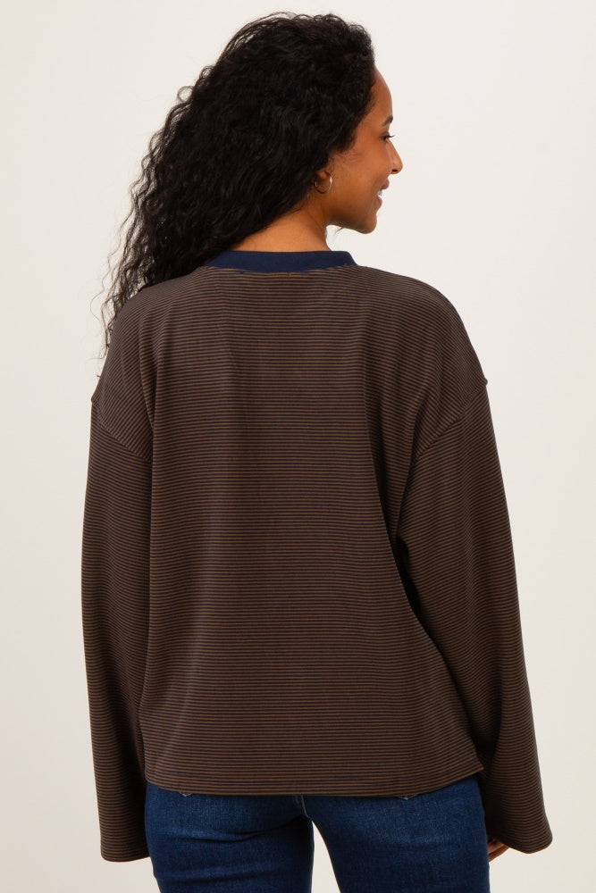 woman wearing a brown striped maternity sweatshirt with a navy neckline, showing a relaxed fit and long sleeves