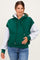 woman wearing a green and gray color-blocked maternity hoodie and holding her baby bump