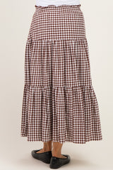 woman wearing a brown and white gingham maternity maxi skirt with tiered ruffles