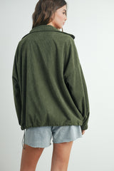 woman wearing an oversized olive green corduroy jacket styled with light denim shorts