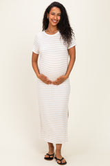 woman wearing a white striped maternity maxi dress and holding her baby bump