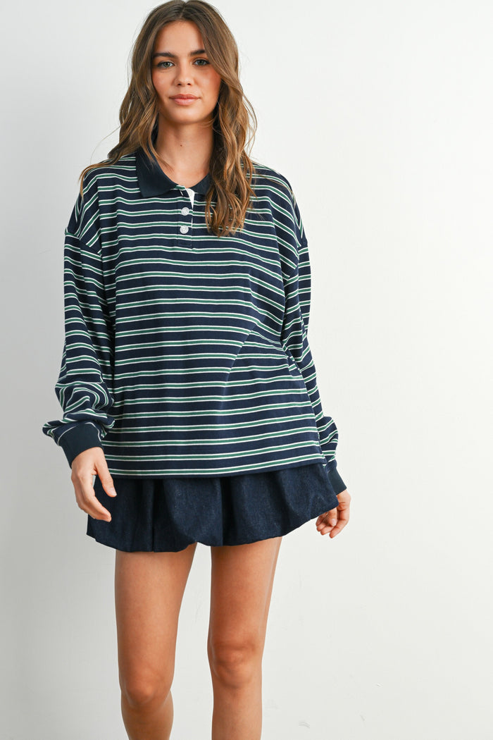 woman wearing a navy and green striped long sleeve polo top paired with a navy skirt