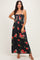 woman wearing a black floral maxi dress with red roses and spaghetti straps