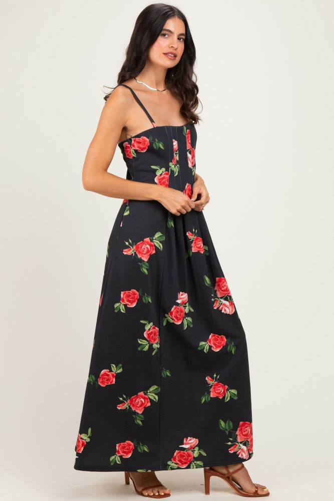 woman wearing a black maxi dress with red rose print and spaghetti straps standing sideways