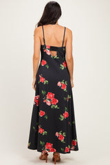 woman wearing a black maxi dress with red floral print and a back cutout, straps visible on shoulders