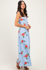 woman wearing a light blue sleeveless maxi dress with a floral rose print