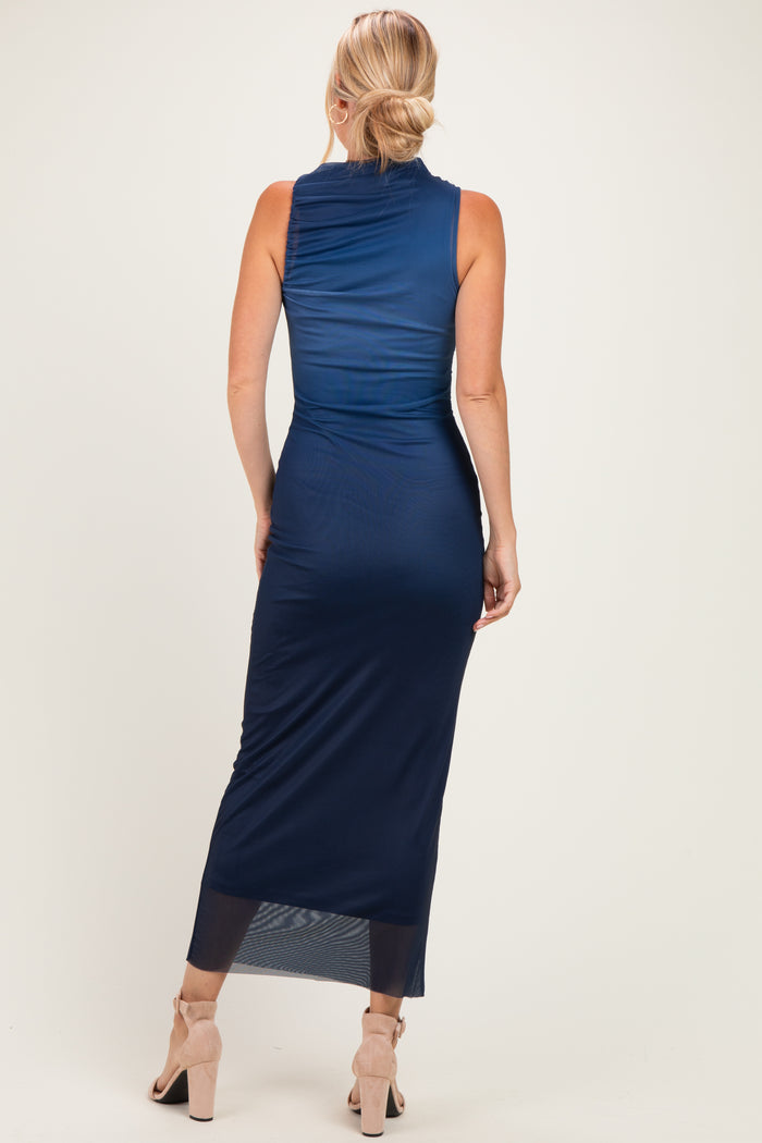 woman wearing a navy blue sleeveless maxi dress with a fitted silhouette and sheer bottom hem, shown from the back