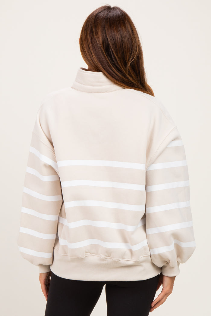 woman wearing a beige striped pullover sweatshirt with balloon sleeves and a high collar, view from the back