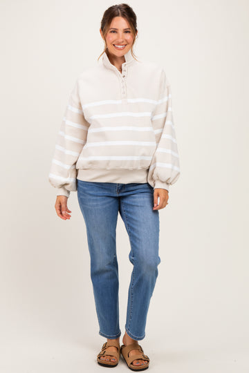 woman wearing a beige striped maternity pullover sweatshirt with a half zip and relaxed fit, paired with blue jeans