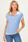 woman wearing a light blue maternity polo sweater with white collar and striped hem, styled with blue jeans