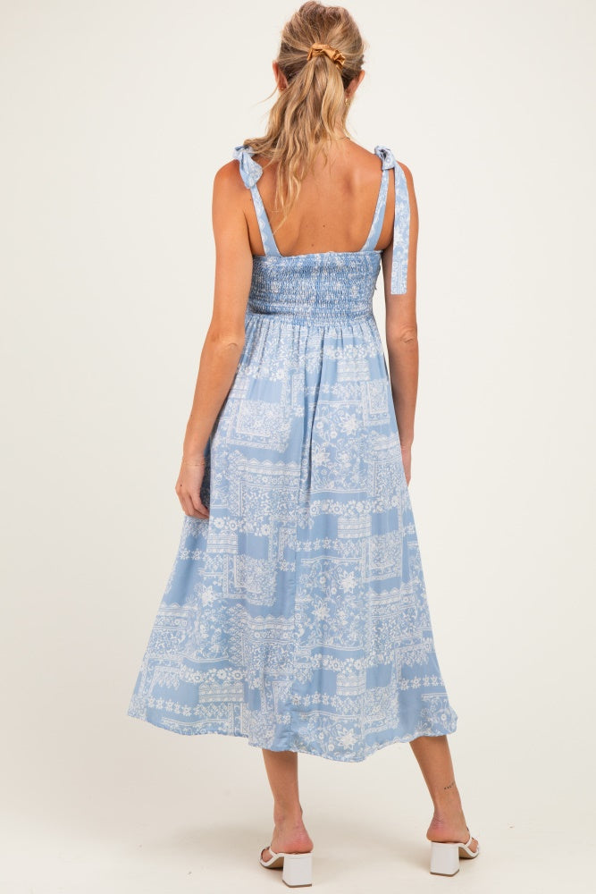 woman wearing a light blue maternity maxi dress with smocked bodice and tie straps, view from the back