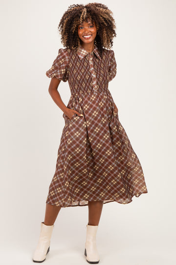 woman wearing a brown plaid maternity dress with short sleeves and pockets