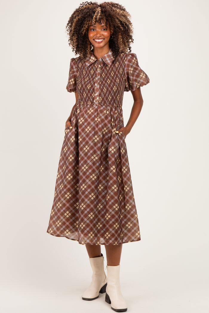 woman wearing a brown plaid maternity dress with short puff sleeves and pockets