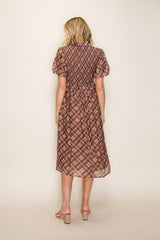 woman wearing a brown plaid midi dress with puff sleeves, showing the back view