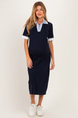 woman wearing a navy blue maternity dress with a collar and short sleeves, showcasing her baby bump