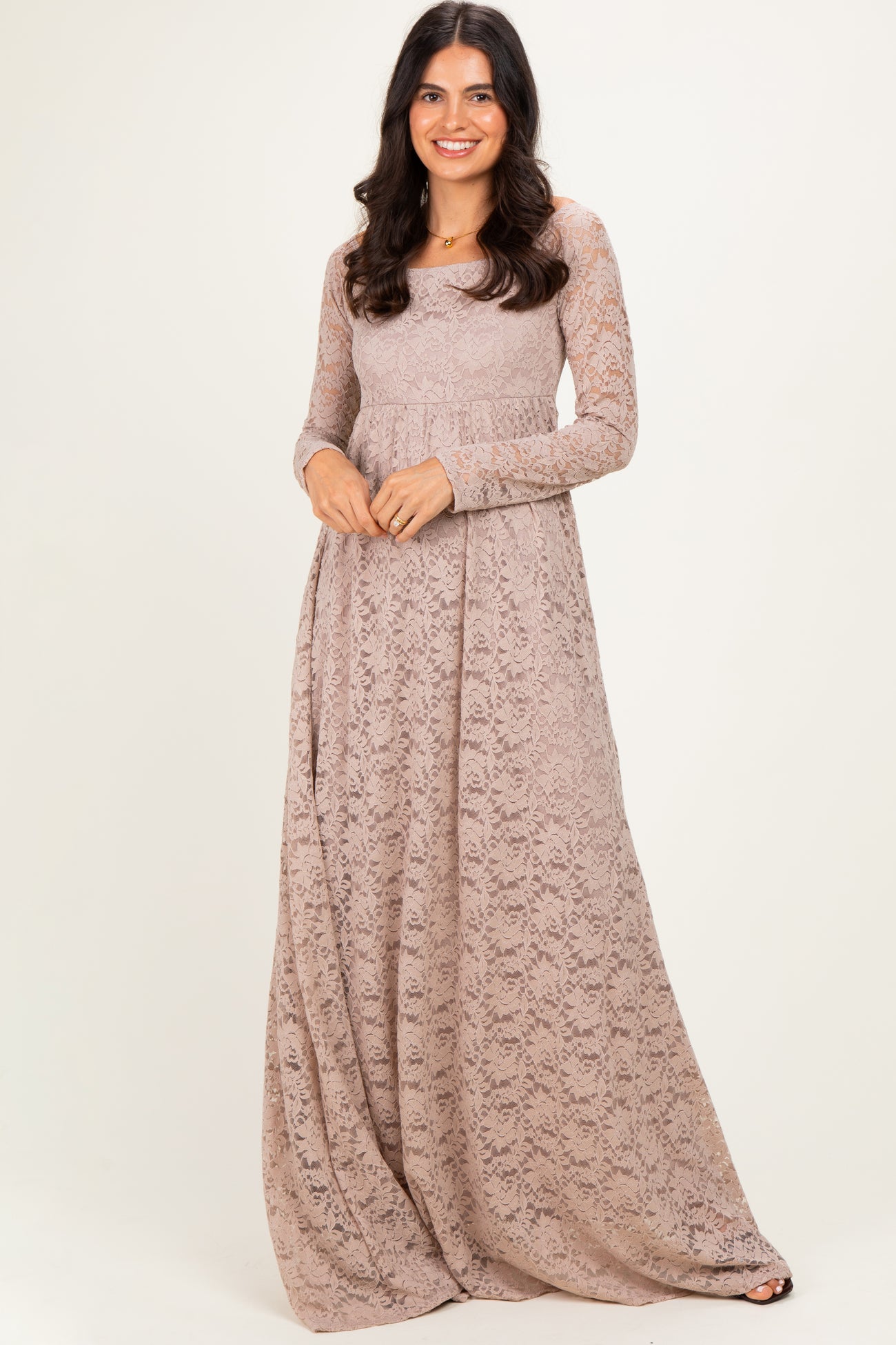 woman wearing a long sleeve taupe lace maxi dress with a flowy skirt