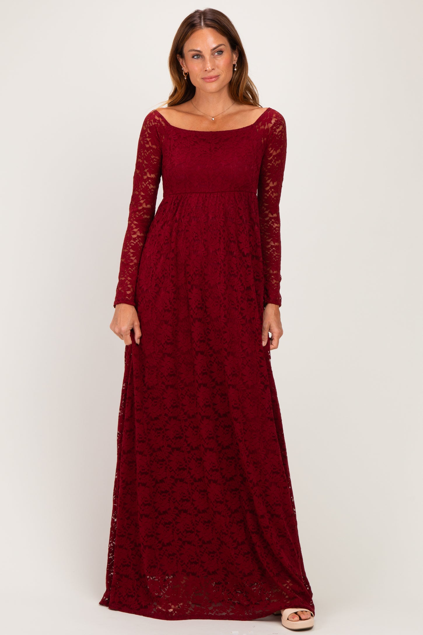 woman wearing a burgundy lace maxi dress with long sleeves and a fitted bodice